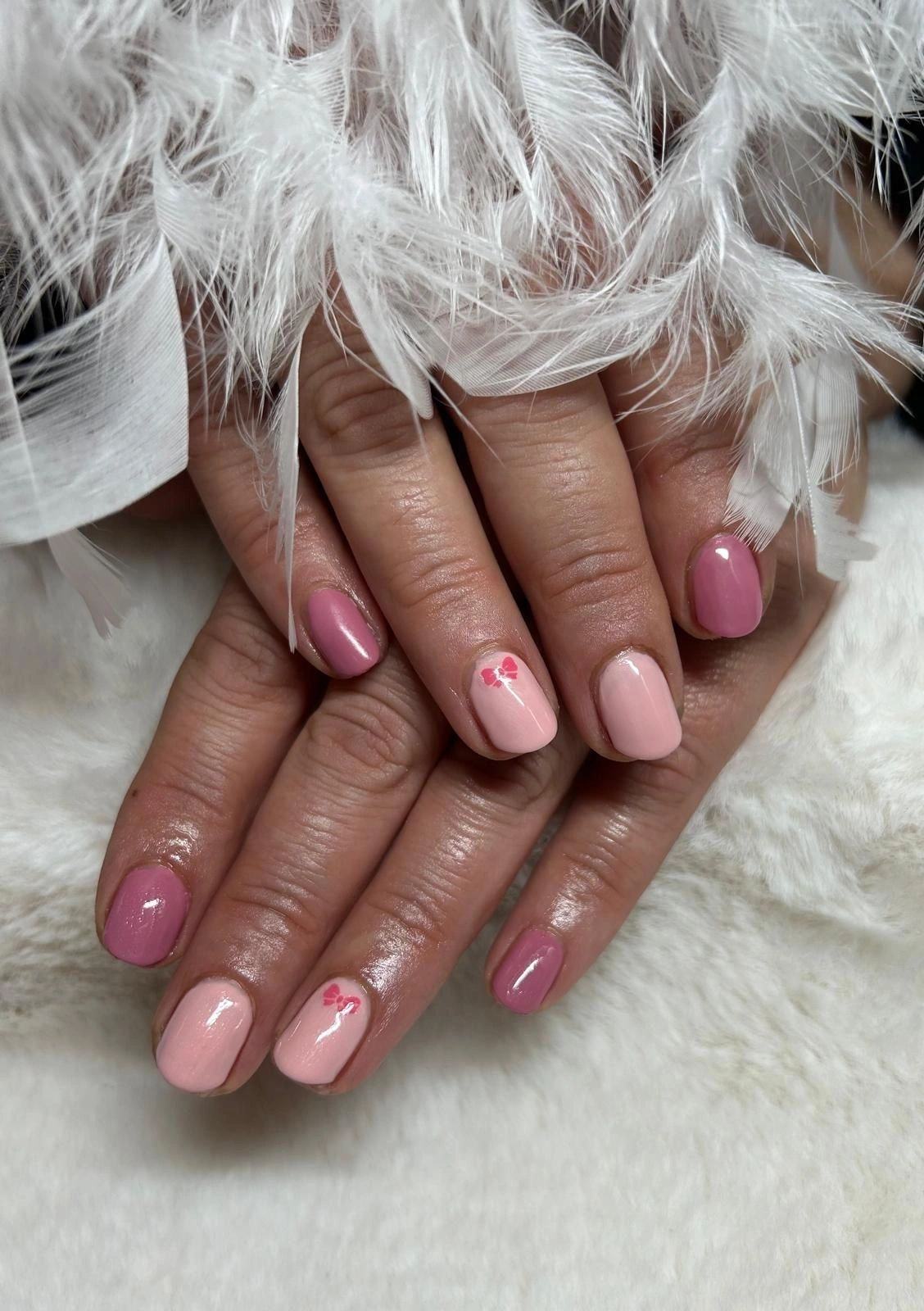 Pastellfarbener Nagellack mit kleinem Design auf hellrosa Nägeln